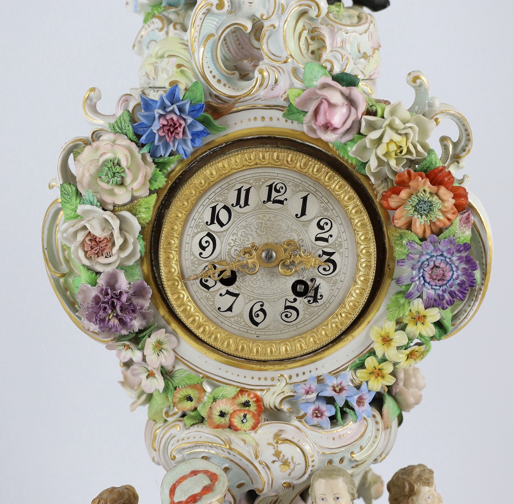 An impressive German porcelain floral encrusted figural mantel clock, late 19th century, Total height 65 cm